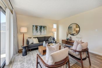 Living room with two tone paint,  hardwood inspired floor, gray/white rug, gray sofa and  mirror